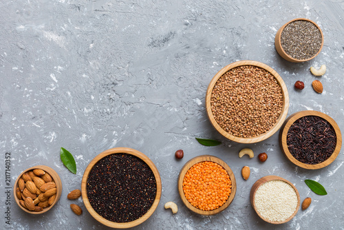 Various superfoods in smal bowl on colored background. Superfood as rice, chia, quinoa, lentils, nuts, sesame seeds, almonds. top view copy space