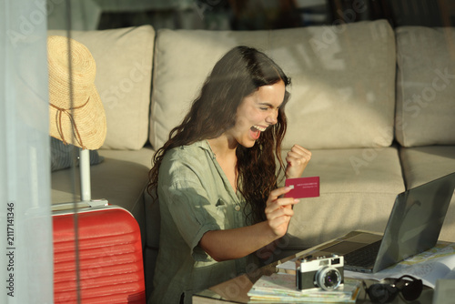 Foto Excited tourist buying online using credit card on vacation