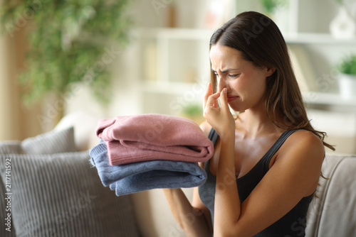 Cuadro en lienzo Woman complaining smelling stinky clothes at home