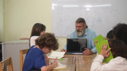 The teacher is teaching young children in a class at school.