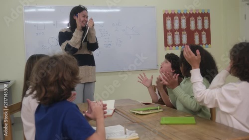 The teacher is teaching young children in a class at school.