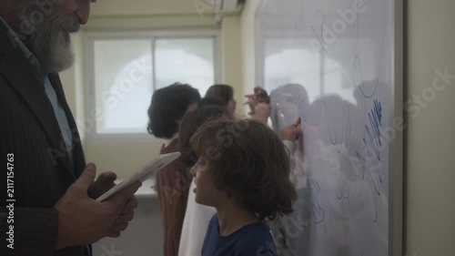 The children are drawing on the whiteboard in the classroom.