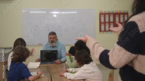 The teacher is teaching the children in the classroom.
