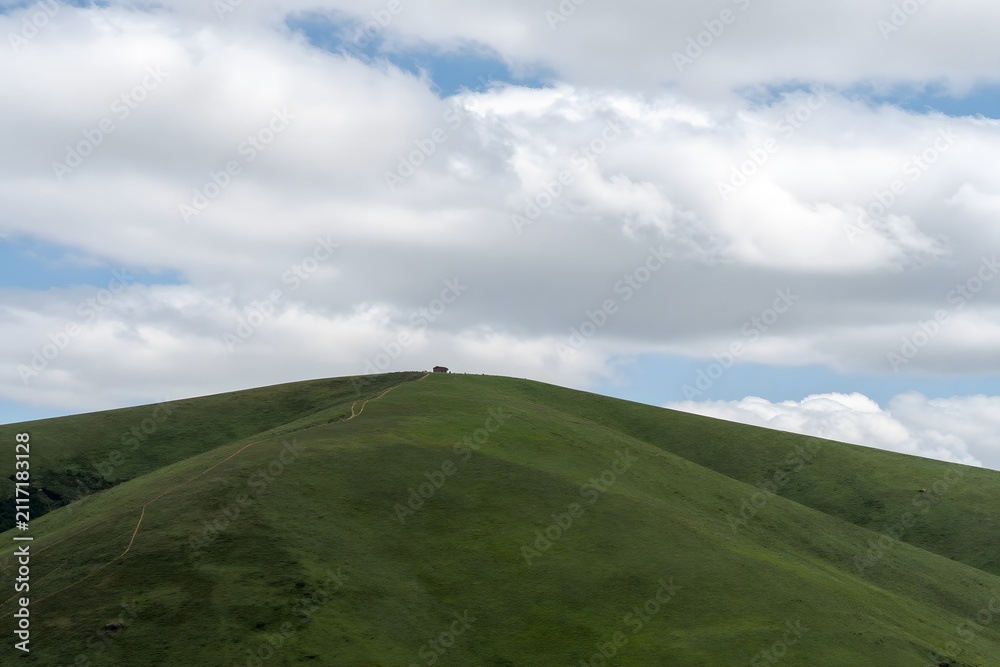Fototapeta premium Green hill landscape with clouds and open sky