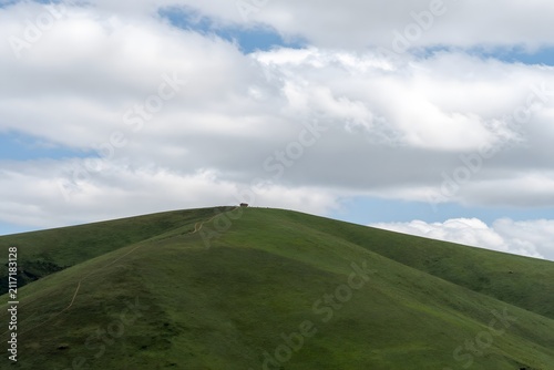 Green hill landscape with clouds and open sky