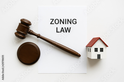 Zoning law document gavel house model legal concept flat lay top view white background urban planning regulation and property legislation displayed together