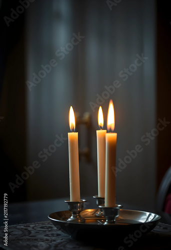 Three lit white taper candl...