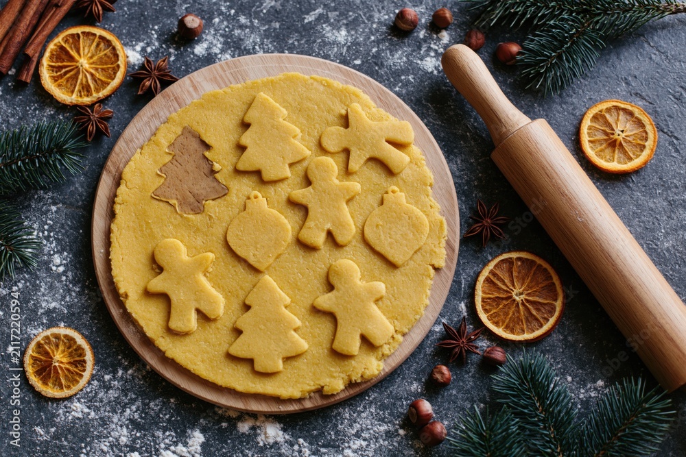 Obraz premium The Cookie Dough on Wooden Board With Holiday Cutout Shapes