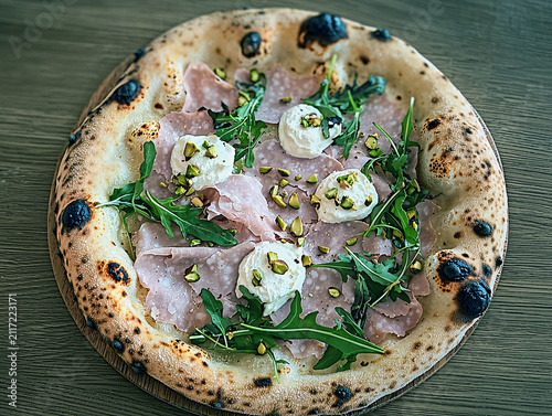Delicious pizza with mortadella, stracciatella, arugula and pistachio