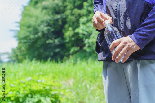 熱中症対策｜炎天下でペットボトルの水を持つ男性