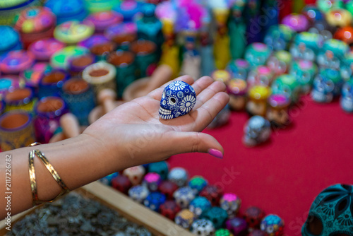 Hand Holding Miniature Blue Ceramic Skull at Traditional Mexican Artisan Market