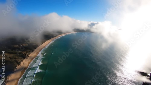 Photorealistic cinematic drone footage capturing a tranquil coastal panorama from high above the ocean.
