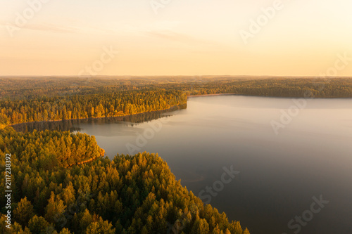 Aerial view on a forest lake at sunrise time