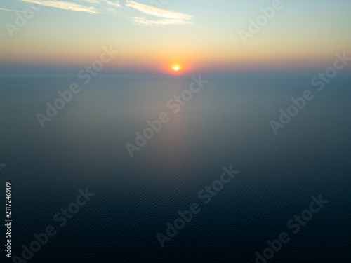 High Aerial View of Golden Sunrise Sunset Over Open Sea Water Horizon