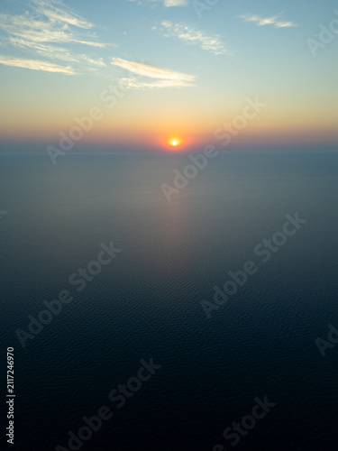 High Aerial View of Golden Sunrise Sunset Over Open Sea Water Horizon