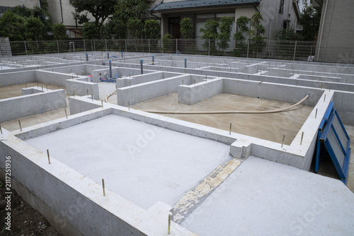 Naklejka 閑静な住宅街における一戸建て住宅の基礎工事と仮設トイレのある風景