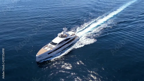 Aerial view of an ultra modern luxury yacht cruising over calm ocean with speed