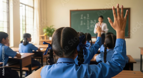 Indian schoolchildren raising hands in classroom during lesson  