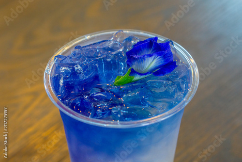 фотографія Close-up of iced butterfly pea tea drink topped with fresh blue pea flower