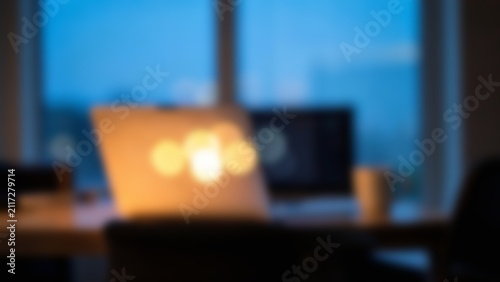 Blurred modern laptop workspace with warm lights for fintech website