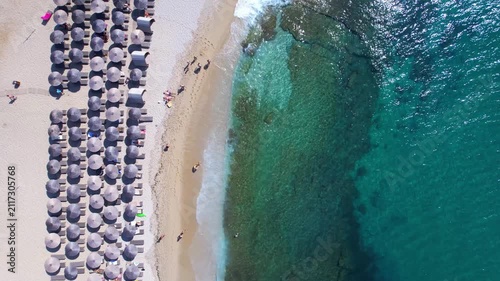 Aerial drone  of a peaceful beach in Thassos, Greece, featuring transparent turquoise water, paddleboards, swimmers and a beautiful Mediterranean coastline.