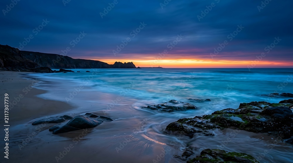 Obraz premium Beautiful sunset over the ocean with dark rocky beach
