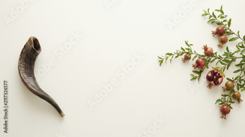 Rosh Hashanah Shofar and Pomegranate Branch on Clean Background, Symbolizing Jewish New Year and Abundance.