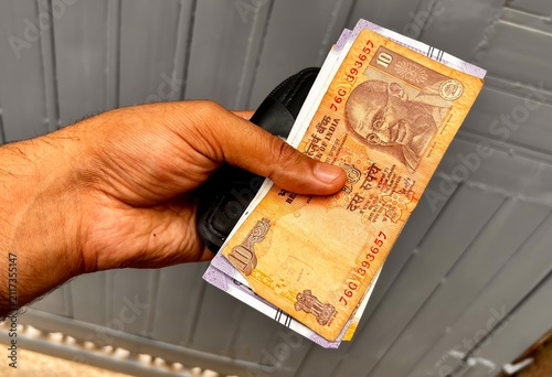 Quadro su tela Close Up of Hand Holding Indian Banknotes and Rupees Concept for Falling GDP Eco