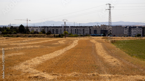 Canvastavla Campo cosechado frente a ciudad con torres eléctricas en Burgos, España