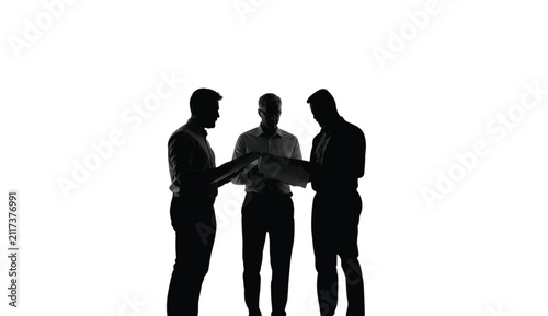 Businesspeople in silhouette stand together to review a large project document, demonstrating professional teamwork and strategic planning in a clean, bright, and modern studio office environment.