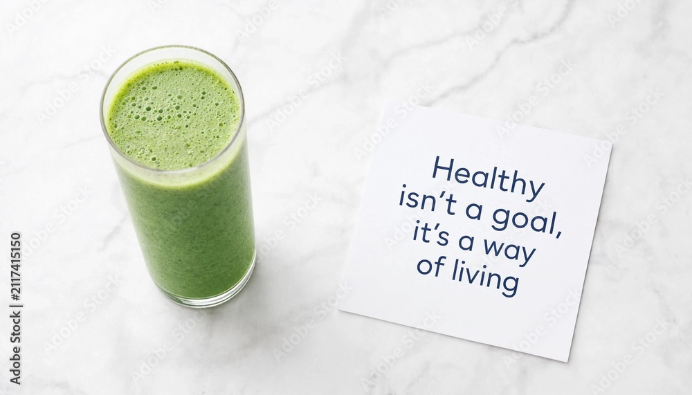 Fototapeta premium Fresh green smoothie in a glass with an inspirational quote on a white marble background