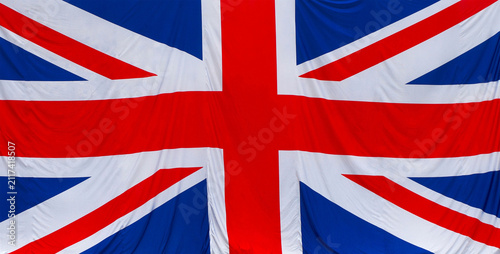 Close up of the United Kingdom flag fabric texture waving with vibrant colors, detailed folds, national symbol, patriotic background, high resolution.