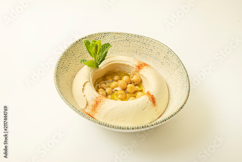 Konstfotografi Alternate angle of hummus swirled with olive oil and chickpeas, sprinkled with paprika, finished with mint leaves