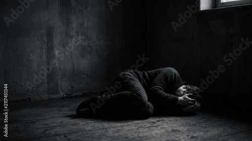 Darkness Envelops A Solitary Figure In A Stark Room