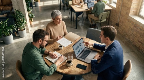 Colleagues Collaborating On Project Data In Modern Office Meeting Space