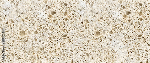 Fotografie Travertine limestone texture with natural porous cellular cavities on light beig