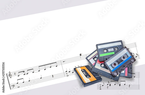 audio cassettes and musical score on whit  background