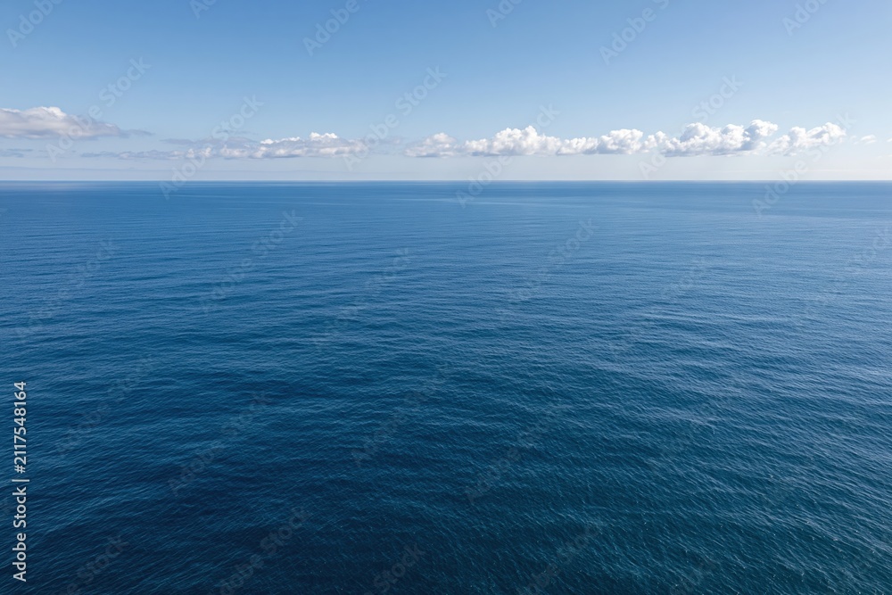 Fototapeta premium The Ocean Horizon: A Vast Blue Seascape Over Calm Sea and Sky