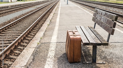 Waiting and Departure Concept, a Lone Suitcase Beside an Empty Railway Platform Bench