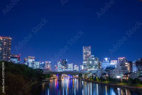 Fotografie 煌めく都会のビル群の明かりが川面に美しく映る夜景素材