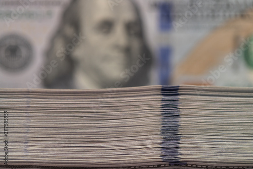 Картината върху платно Side view macro stack of hundred US dollar bills with blurred background