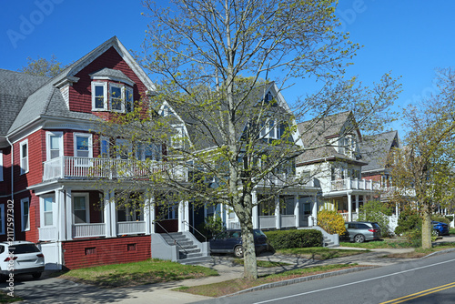suburban street of three story clapboard houses with large verandas