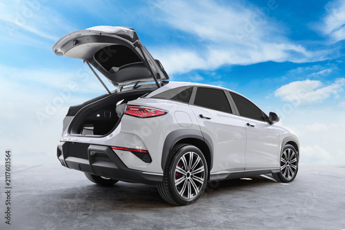 Фотография White Electric SUV with Open Rear Trunk parked in a parking lot under the sky