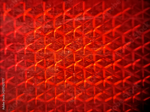Bild auf Leinwand Abstract close-up background texture of a red safety vehicle reflector with a honeycombed geometric pattern