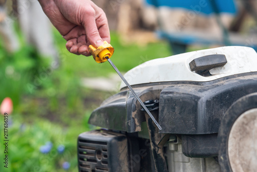 Checking the oil level in the cultivator with a dipstick