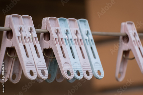 Quadro su tela Clothes pegs hang on a line in a backyard during a sunny afternoon