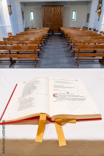 Naklejka Open missal on altar with empty chapel seating