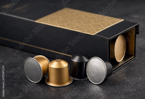 Premium black and gold packaging box with luxury coffee capsules on a dark surface for high-end brand presentation