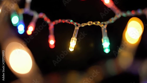 Vibrant colorful LED Christmas lights blinking on a dark background for festive holidays