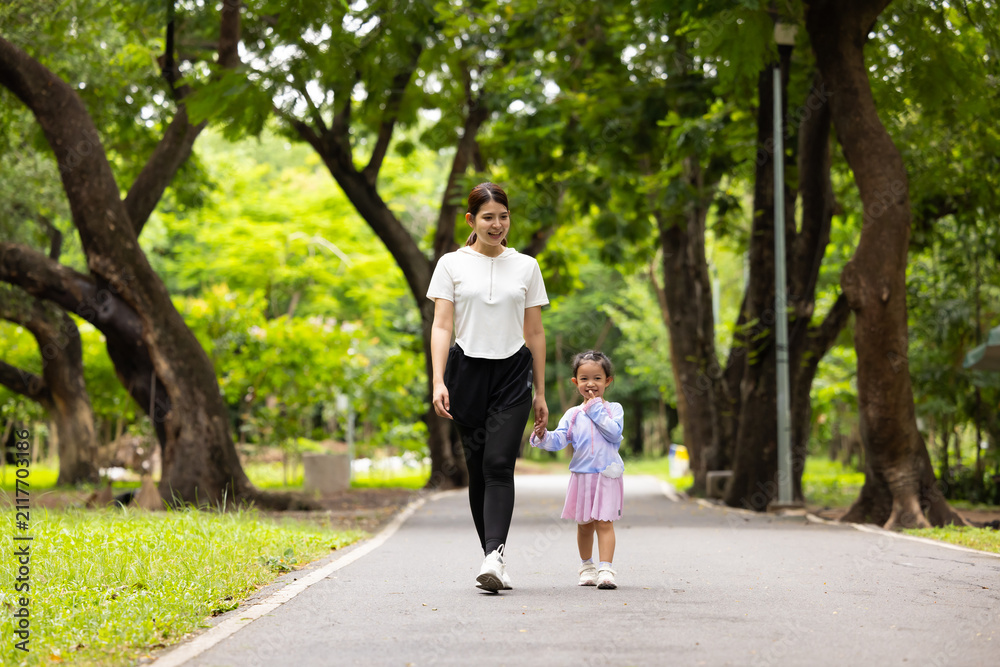 Fototapeta premium Energy, Asian girl and mother running outdoor for child development or growth. Adventure, excited and path with happy kid in nature park for outdoors activity. Healthy outdoor sport for kids.